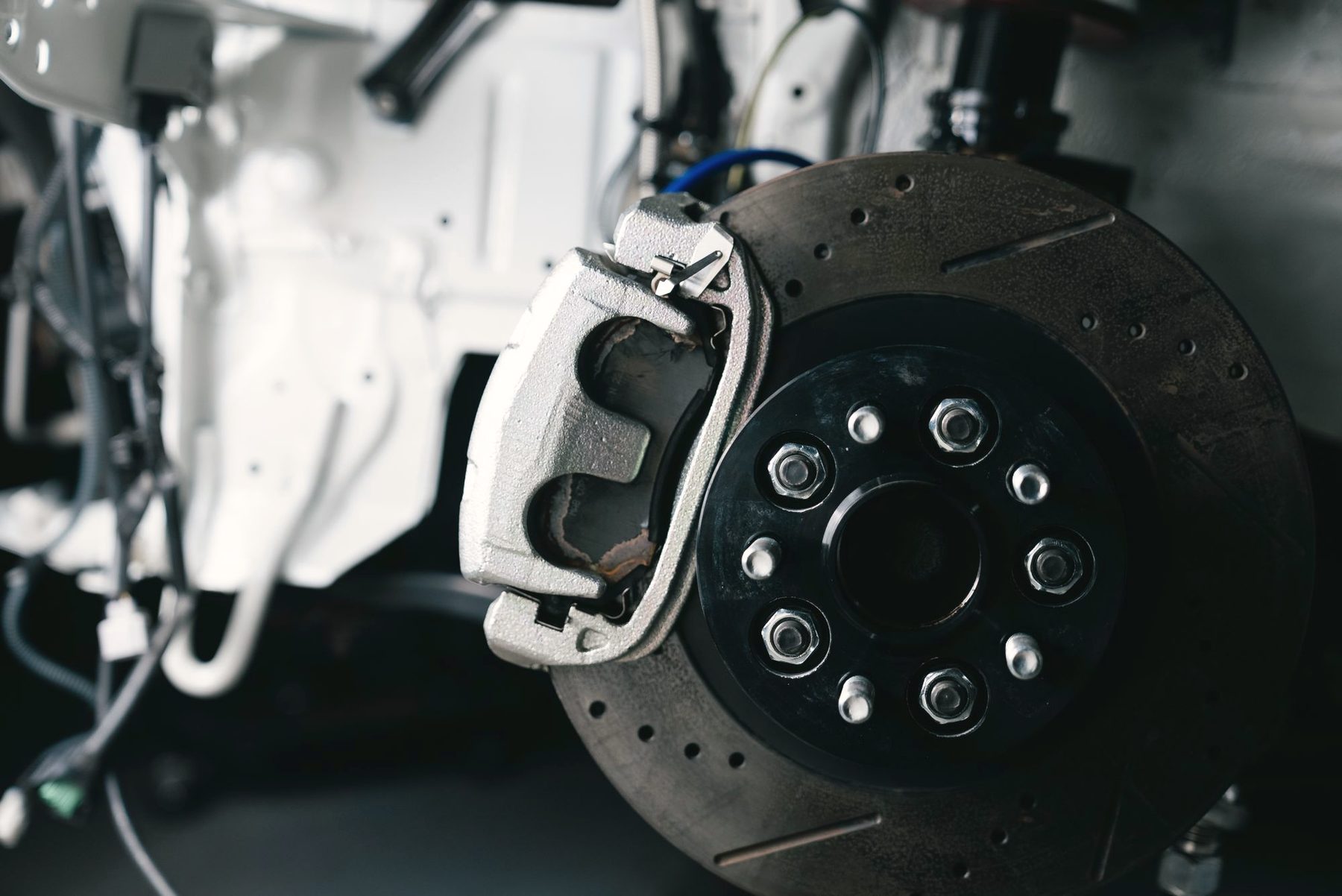 A brake disc and caliper exposed with the road wheel removed.