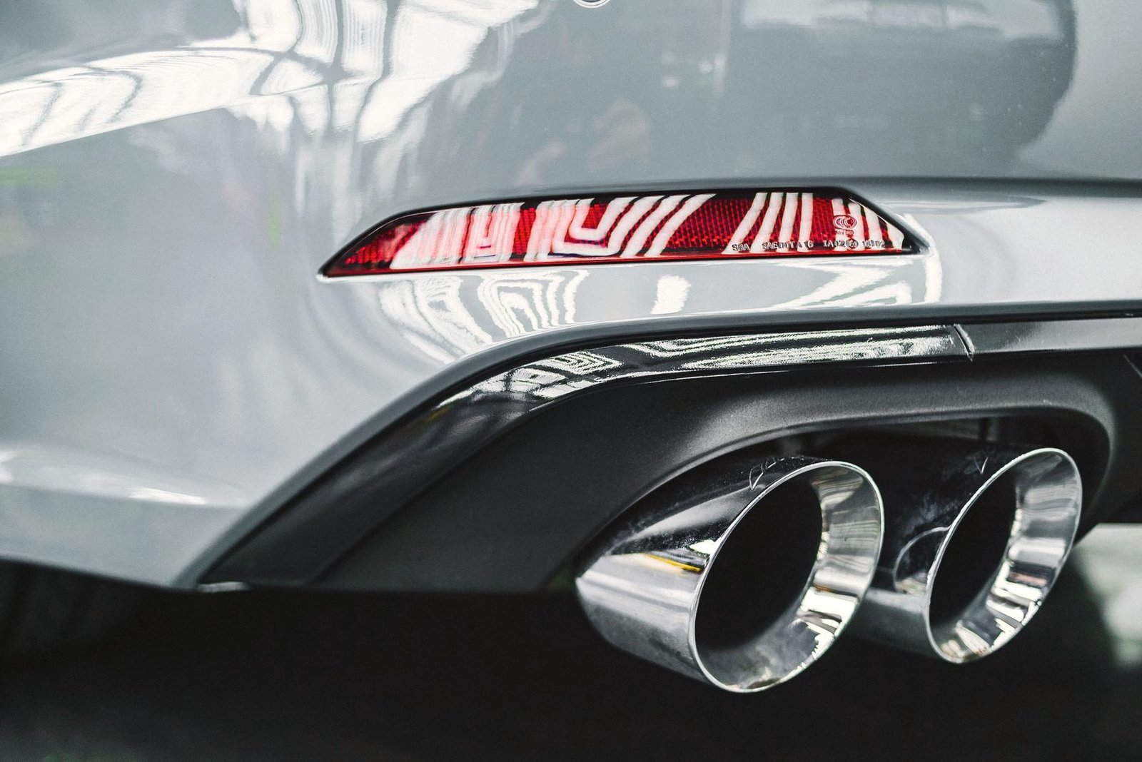 Chrome exhaust tips set into the rear valance of a car.