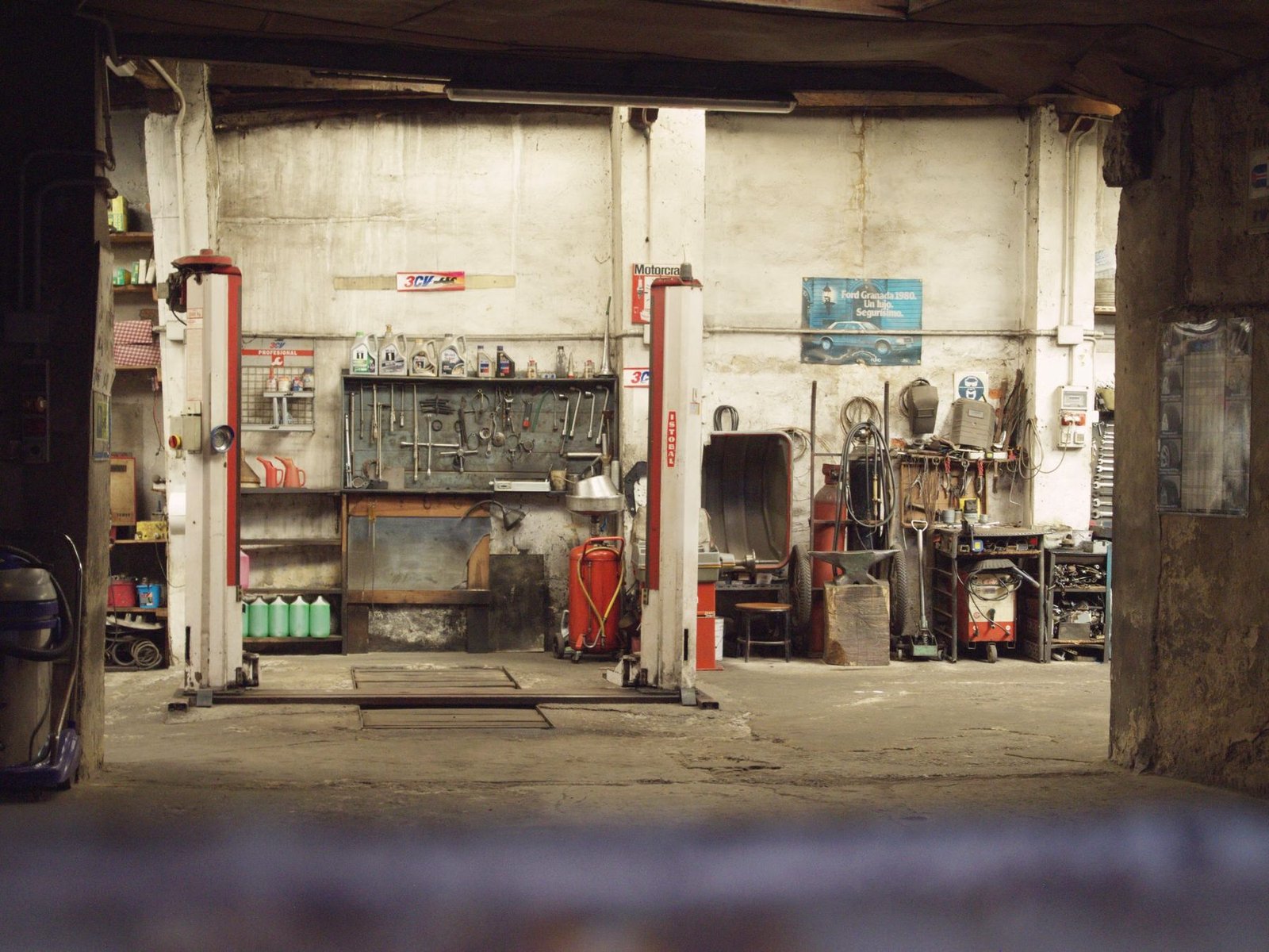 An empty repair shop with two vehicle lifts standing open.