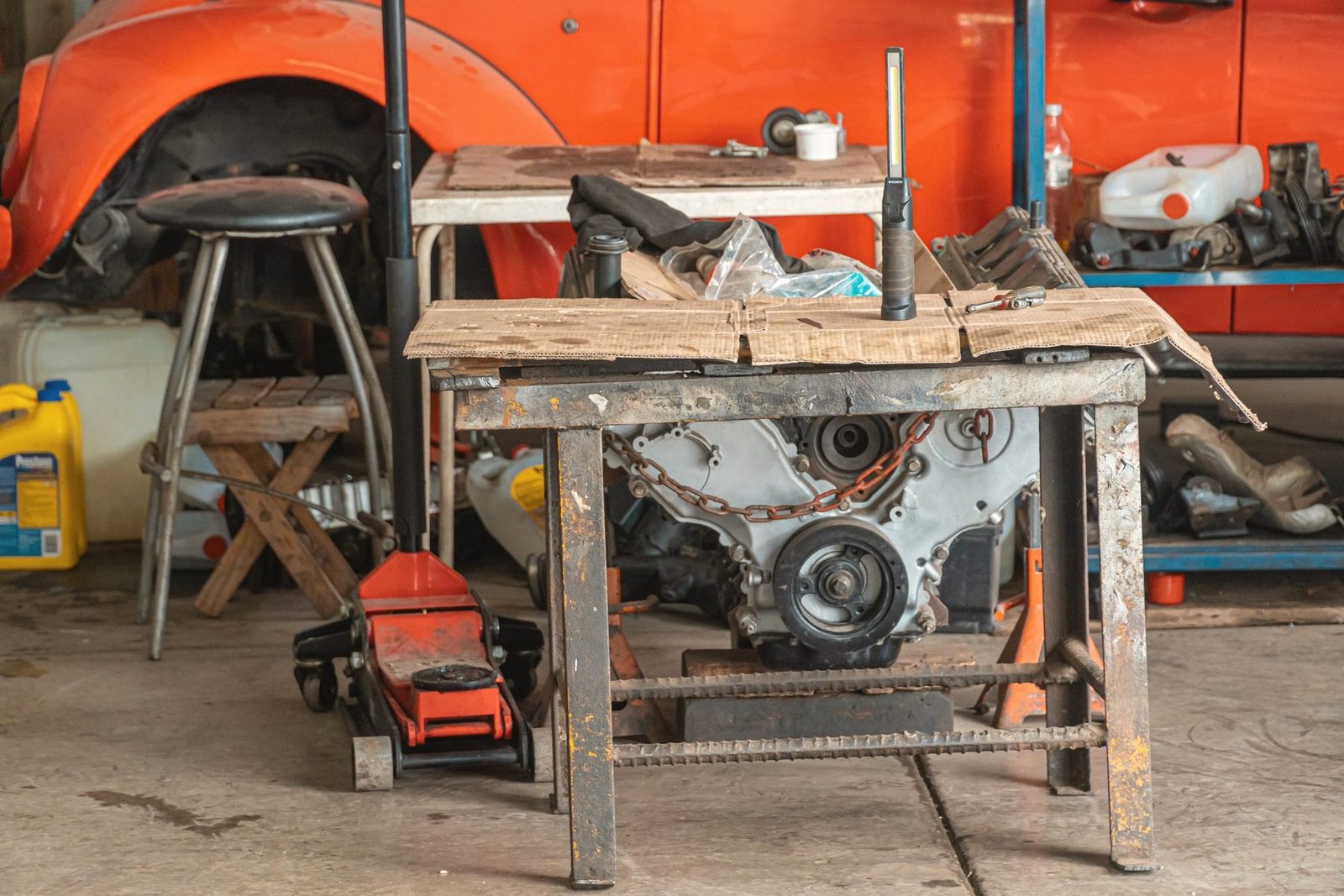 An engine block resting on a wooden workshop table in a repair bay.