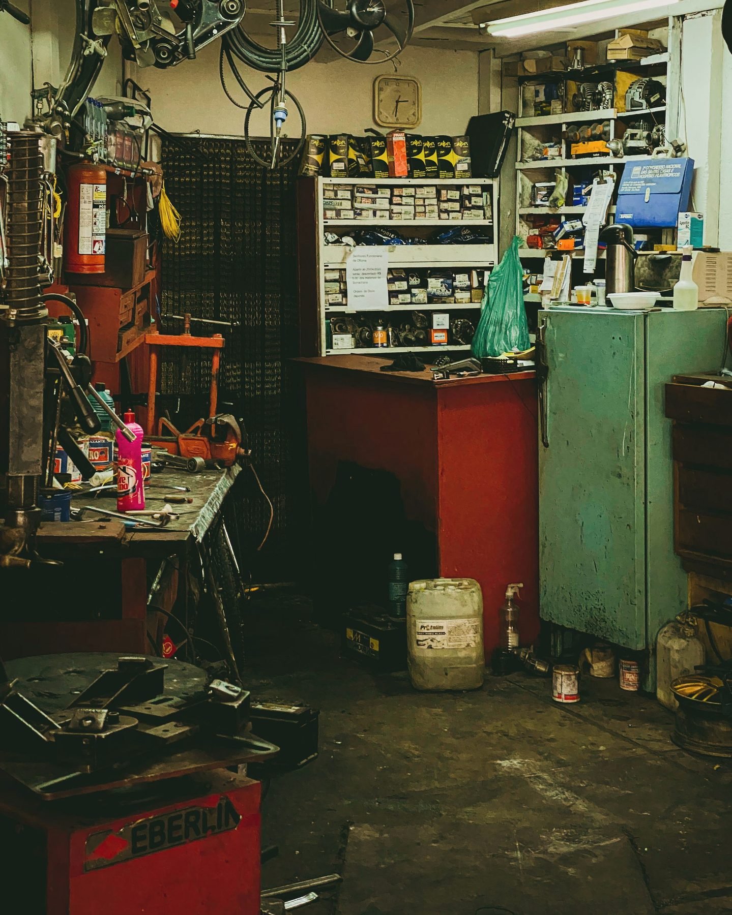 Wide view across a working auto repair shop floor with equipment and benches.