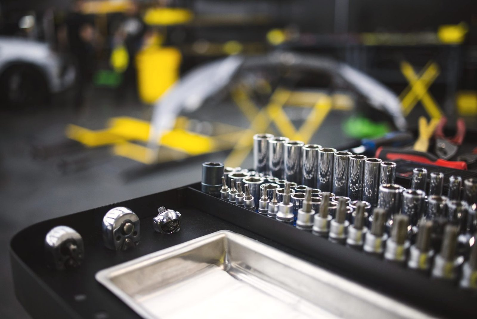 A socket set laid out in a tray on a bench.